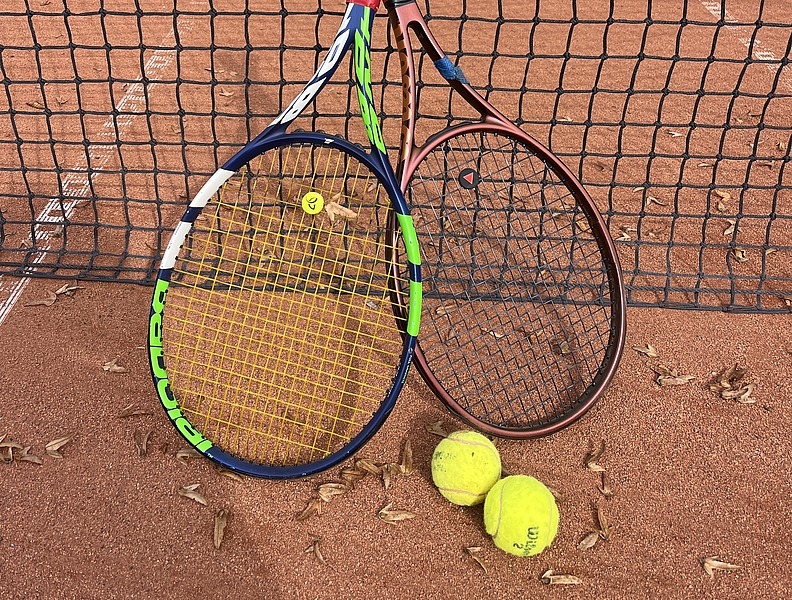 Tennisschläger vor Tennisnetz